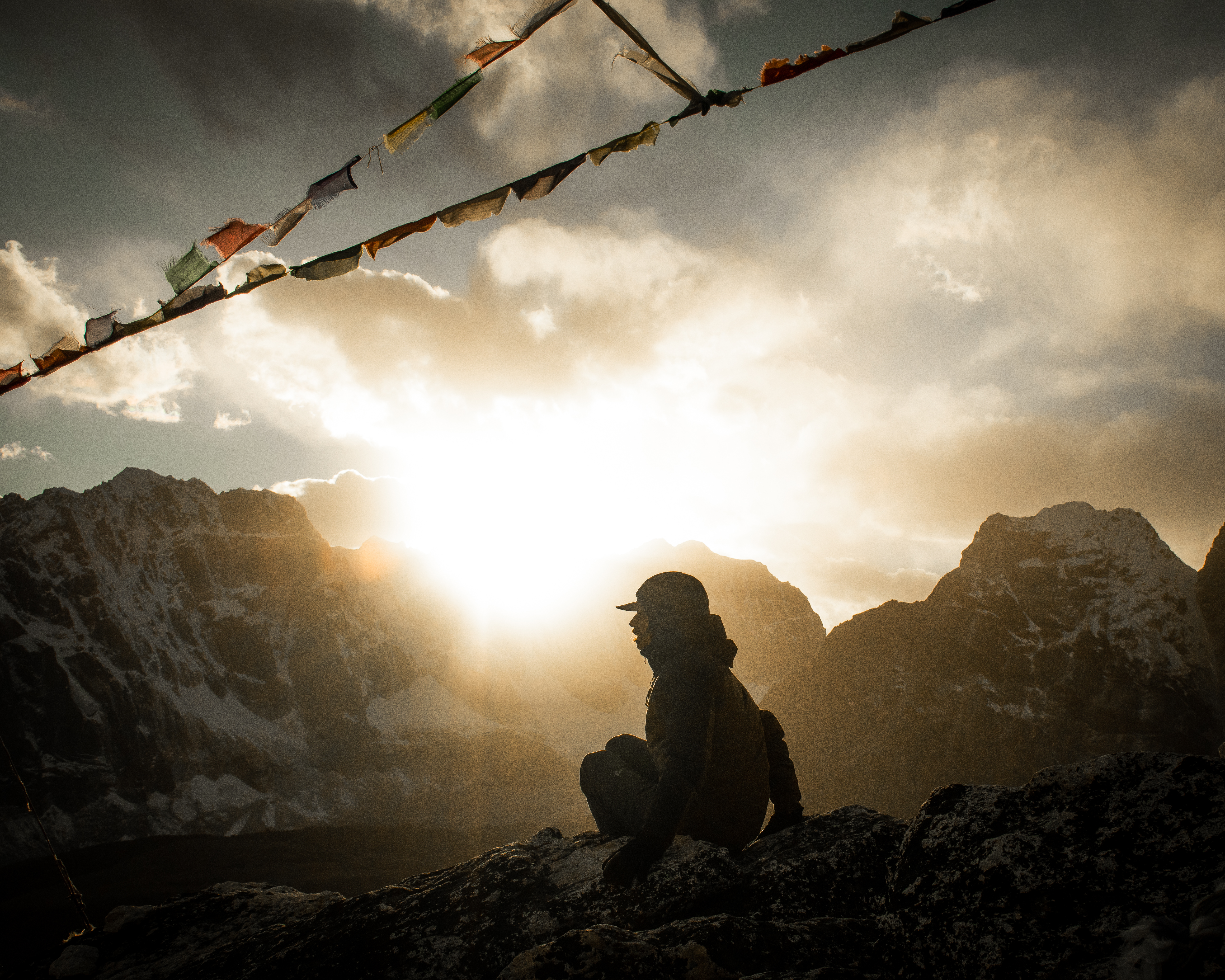 Man sitting on top of Himmalayan mountain at sunset